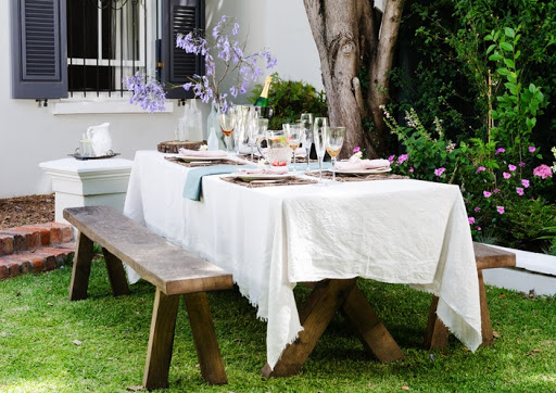 Table setting for an casual outdoor garden party with neutral nude color scheme